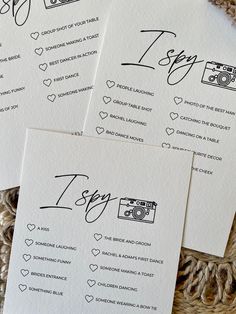 wedding stationery with handwritten calligraphy on white paper, including camera and hearts