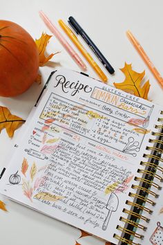 the recipe book is open and ready to be filled with autumn leaves, pumpkins, and writing utensils