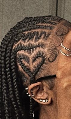 a woman with cornrows and tattoos on her head