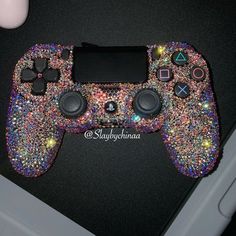 a game controller covered in multicolored glitters and other things next to a computer mouse