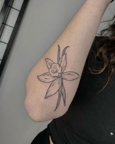 a woman's arm with a flower tattoo on the left side of her arm