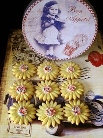 some yellow flowers are sitting next to a plate with an old fashioned photo on it