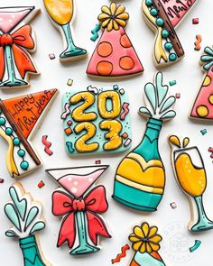 decorated cookies are arranged in the shape of birthday hats, champagnes and cocktail glasses