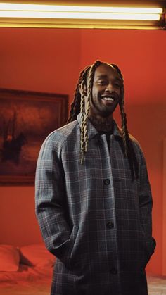 a man with dreadlocks standing in a room