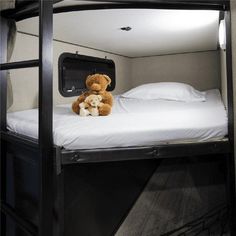 a teddy bear sitting on top of a bunk bed