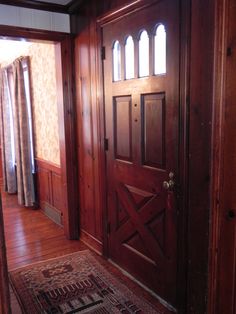 an empty room with wood paneling and arched windows on either side of the door