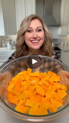 a woman holding a bowl full of cut up vegetables