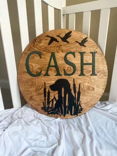 a wooden sign that says cash on the side of a white crib with birds flying over it