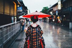 a woman with an umbrella walks down the street