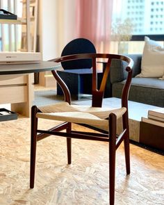 a wooden chair sitting on top of a hard wood floor next to a desk and couch