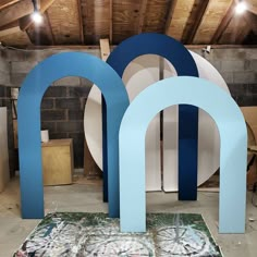 two large blue and white letters sitting on top of a floor next to a wall