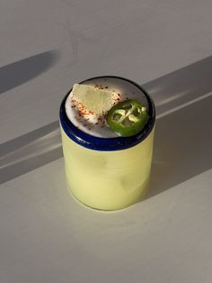 a glass with some food in it on a white counter top next to a spoon