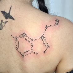 the back of a woman's shoulder with tattoos on it and an origami bird