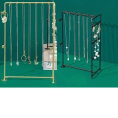 a jewelry rack with several necklaces hanging from it's sides and a box on the other side