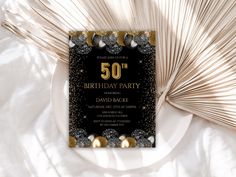 a 50th birthday party card with gold and silver decorations on top of a white plate