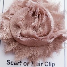 a piece of fabric that is sitting on top of a clipping paper with the words scarf or hair clip written below it