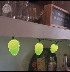 some lights that are on the side of a shelf in a room with bottles and glasses