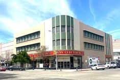 an empty parking lot in front of a building with cars parked on the side of it