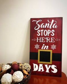 a sign that says santa stops here in days next to a basket of mushrooms on a table