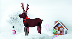 a wooden reindeer standing on top of snow covered ground