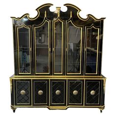 an antique black and gold china cabinet