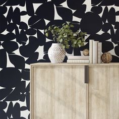 a black and white wallpaper with an abstract design in the corner, next to a wooden cabinet