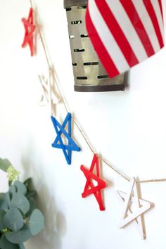 an american flag is hanging on a wall next to some stars and a clock tower