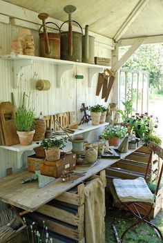 an outdoor room with lots of potted plants on the table and shelves above it