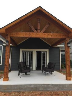 an outdoor covered patio with chairs and tables on it's side walk next to the front door