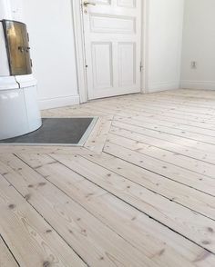 an empty room with white walls and wood floors