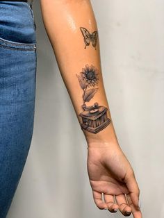 a woman's arm with a tattoo on it that has a record player and sunflower