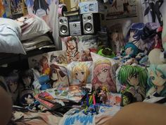 a room filled with lots of anime pillows and pictures on the wall behind it,