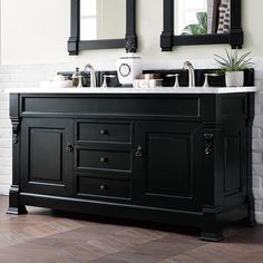 a bathroom vanity with two sinks and mirrors on the wall next to a brick wall