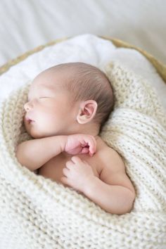 a newborn baby is sleeping in a basket