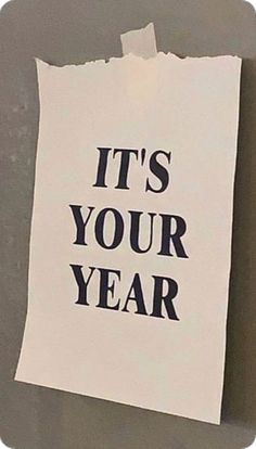 a piece of paper with the words it's your year on it hanging on a wall