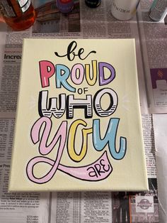 a piece of paper with the words be proud of who you are painted on it