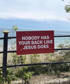 a red sign that says nobody has your back like jesus does next to a fence