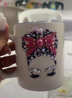 a hand holding a coffee mug with an image of a woman's face on it