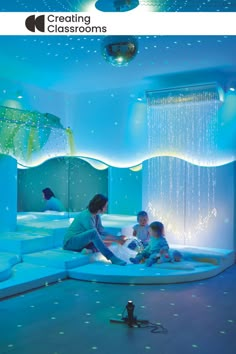 two children are sitting on a circular bed in the middle of a room with blue lights