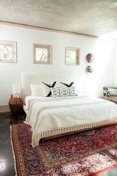 a bed sitting on top of a rug in a bedroom