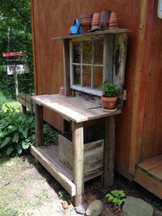 a potted plant sitting on top of a wooden table next to a building with windows