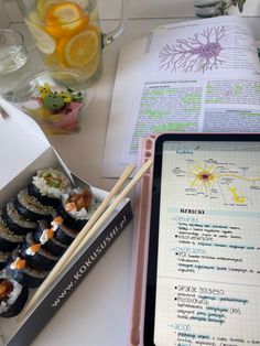 sushi and chopsticks are sitting on a table next to an open book