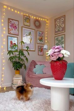 a small dog standing in the middle of a living room with flowers on the table