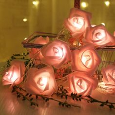 a bunch of pink roses sitting on top of a table next to a basket filled with flowers