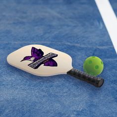 a tennis racket and ball laying on the court