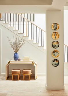 a table with two stools and three plates on the wall