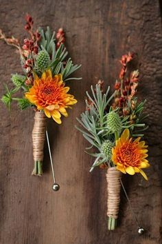 two vases with flowers are sitting on a wooden table and one is tied to the wall