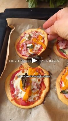 four mini pizzas with cheese and pepperoni on them are being held by a person