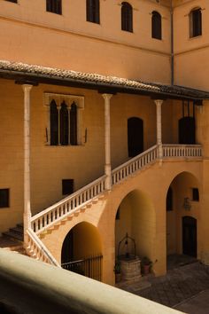 an old building with stairs leading up to the second floor and another one on the other side