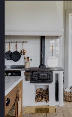 an old fashioned stove is in the middle of a kitchen with white walls and wood flooring